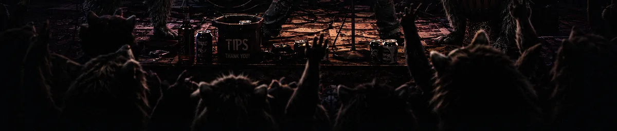 The crowd from the stage: paws raised in the dark, the tips bucket on the stage lip